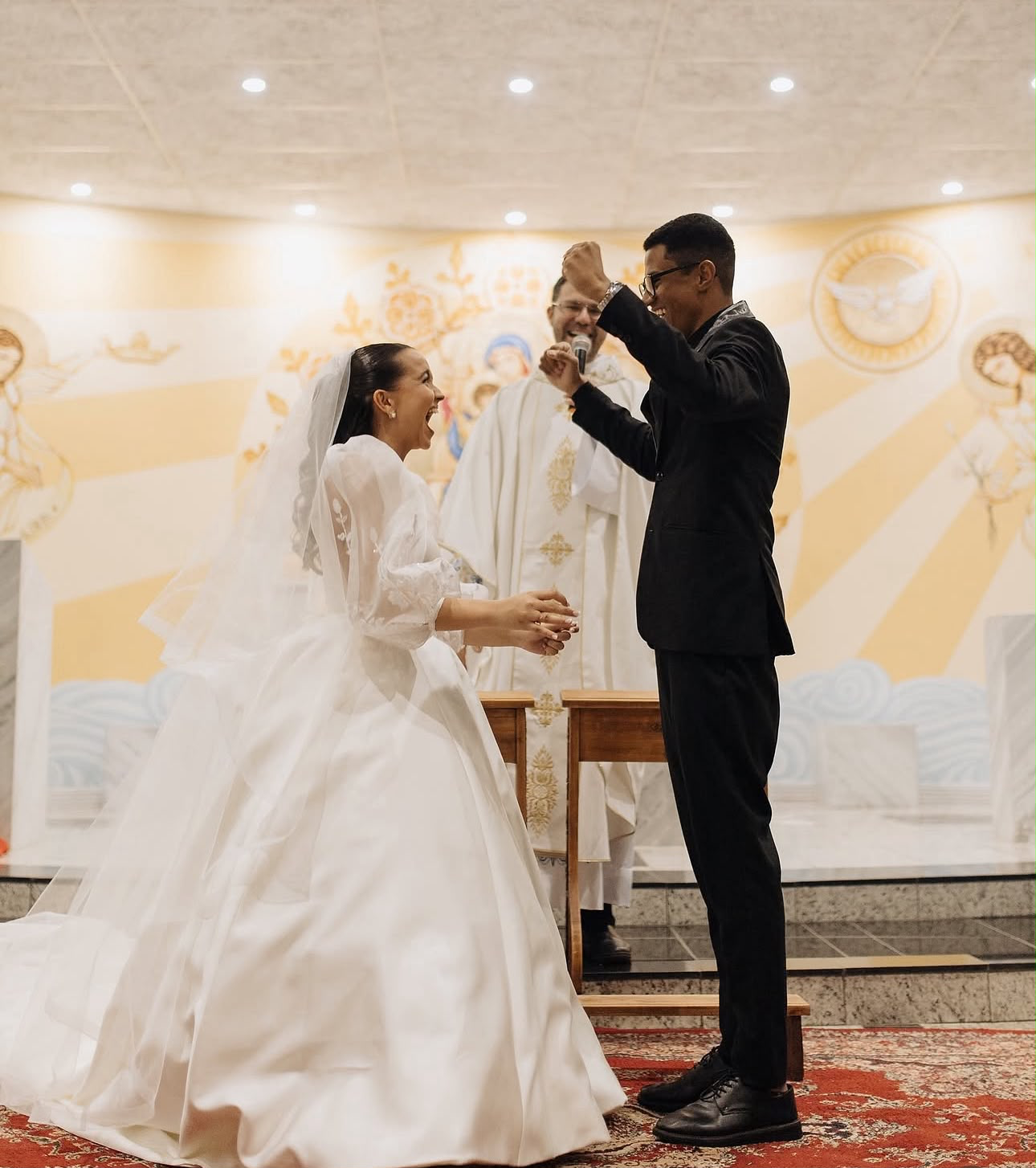 Casal celebrando a troca de alianças, fotografia de Iris Juana